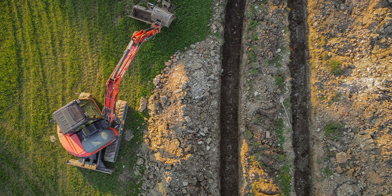 Digger creating tunnels for ground source heating